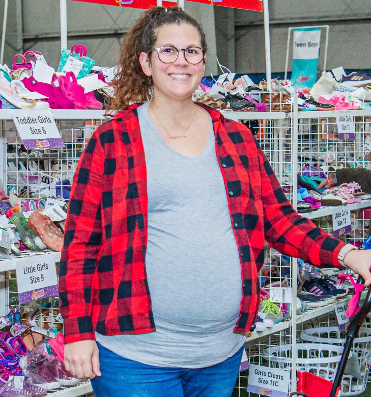 Pregnant woman smiles as she is shopping.